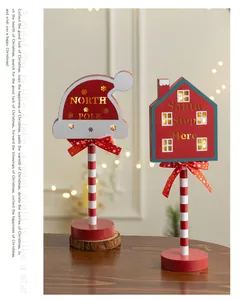 Detail showing illuminated North Pole and Santa Stop Here wooden Christmas signs