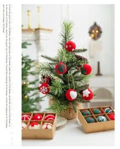 Vista detallada de bolas de Navidad de fieltro hechas a mano en árbol y cajas regalo.