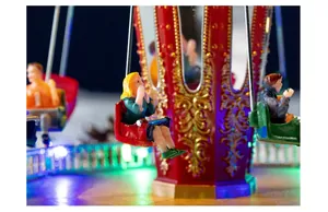Detail van een lichtgevende kerstmuziekdoos met miniatuurfiguren op zweefmolens.