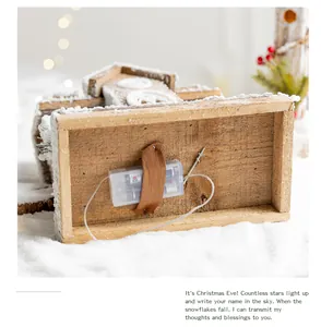 Detailed bottom view of a glowing Nordic wooden Christmas house showing its battery compartment
