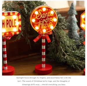 Festive 'Santa Stop Here' wooden LED road sign ornament displayed on a wooden table.