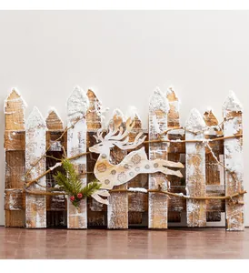 Close-up of wooden Christmas fence with reindeer cutout and snowy finish