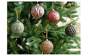 Detailed shot of various patterned Christmas ball ornaments hanging on a pine tree