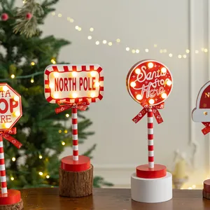 Festive wooden LED Christmas road signs with North Pole and Santa Stop Here text.