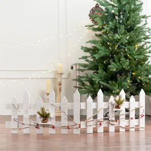 Nordic style white wooden Christmas tree fence with festive pine cones and red berries