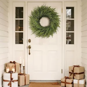 Couronne de pin de Norfolk sur une porte blanche avec des cadeaux de Noël décoratifs