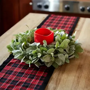 Detailed view of artificial lamb's ear wreath with a red candle on a plaid table runner