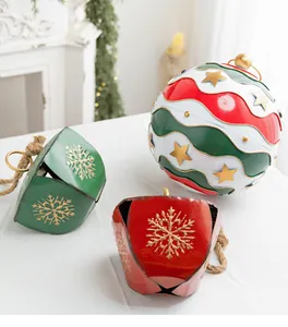 Vue détaillée des cloches de Noël en métal peintes et de la boule rayée assortie