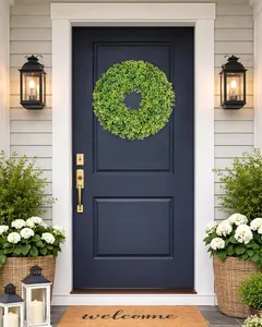 Lush green boxwood wreath hanging on a navy blue front door in a cozy home setting