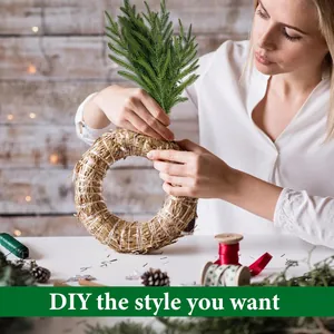 Gros plan d'une femme confectionnant une couronne de Noël avec des branches de pin