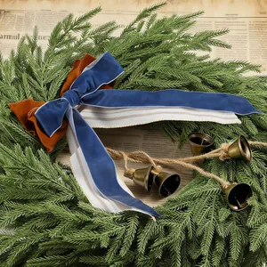 Dettaglio ghirlanda di pino con fiocco in velluto blu e campanelli in rame vintage.