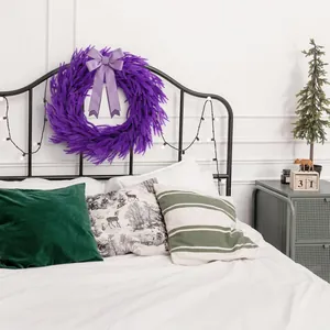Splendida ghirlanda natalizia viola di pino Norfolk appesa a una testiera del letto chic