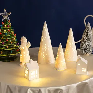 Árboles de Navidad y Papá Noel de cerámica blanca iluminados con luz cálida suave
