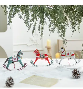 Set of three vintage iron rocking horse Christmas ornaments displayed on a snow background