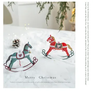 Vintage metal rocking horse Christmas ornaments in red and teal on white faux snow backdrop