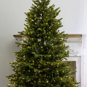 Detailed view of warm LED copper wire lights glowing on green Christmas tree branches.