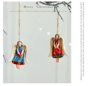 Vintage painted resin angel ornaments hanging on a rustic branch for Christmas decor
