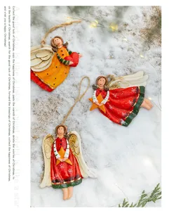 Close-up detail of three retro resin angel ornaments on snow with festive fairy lights