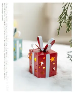 Gros plan d'une boîte cadeau de Noël en métal rouge avec des étoiles ajourées et lumière LED