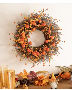 Detail view of harvest autumn wreath with orange pumpkins and berries hanging on a wall