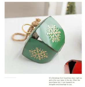 Vue rapprochée d'une cloche de Noël en métal vert avec des flocons dorés.