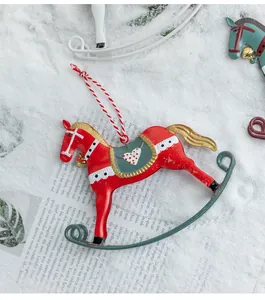 Close-up detail of a vintage red iron rocking horse Christmas ornament on a snowy background