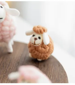 Macro view of a cute handmade brown wool felt sheep figurine for Christmas desk decor.