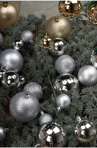 Close-up of assorted gold and silver Christmas baubles in matte and glitter finishes.
