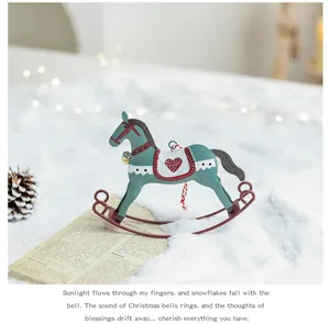 Close-up of vintage teal metal rocking horse ornament with heart detail on snow