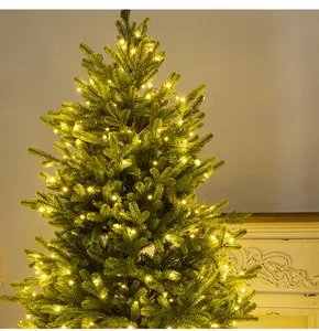 A close-up shot showing warm white LED string lights glowing on a lush green Christmas tree.