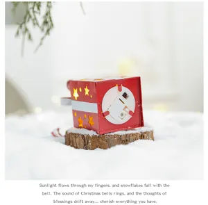 Gros plan détaillé d'un petit coffret cadeau de Noël rouge lumineux sur de la fausse neige.