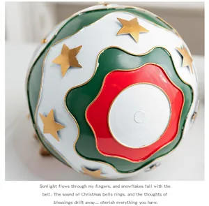 Gros plan d'une boule de Noël en métal peinte avec étoiles dorées et motifs ondulés