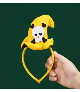 Close-up of yellow Halloween witch hat headband with skull motif for party decor.