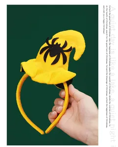 Close-up of yellow Halloween headband with black spider witch hat design