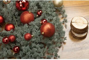 Detailed view of assorted red Christmas baubles on pine needles