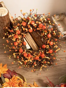 Detailed view of autumn harvest wreath with mini pumpkins and orange berries on twigs