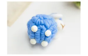 Detailed macro view of a handmade blue wool felt sheep ornament for Christmas decor.