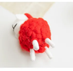 Detailed view of a handmade red felt sheep ornament for Nordic style desk decor.