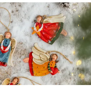 Close-up of hand-painted resin angel ornaments with distressed details on snowy background