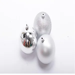 Detail of three silver Christmas ball ornaments with glitter, matte, and glossy finishes.