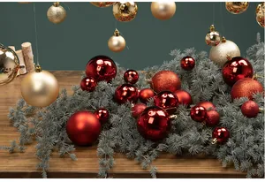 Detailed view of red and gold Christmas ball ornaments displayed on a green pine branch