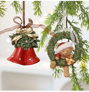 Detailed view of resin Christmas ornaments featuring red bells and teddy bear wreath.