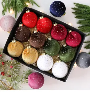 Primer plano de bolas de Navidad de terciopelo de colores con lunares en una caja de regalo negra