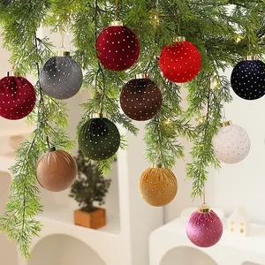 Detalle de bolas de Navidad de terciopelo con lunares colgadas en una rama.