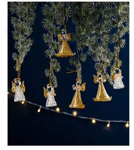 Goldene und klare Kristall-Engel-Mädchen-Ornamente an Weihnachtsbaumzweigen hängend