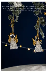 Detailansicht von Kristallglas-Engel-Anhängern mit goldenen Flügeln an Weihnachtsbaumzweigen