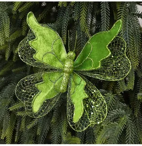Close-up of a green glitter butterfly Christmas tree ornament with mesh wings on branches