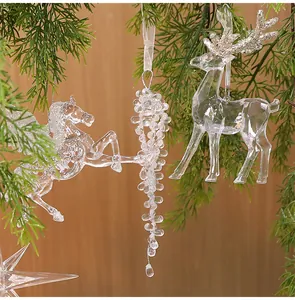 Close-up of clear acrylic Christmas ornaments hanging on a festive tree branch.