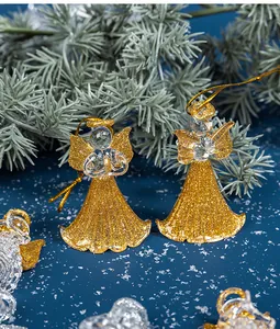 Detail von goldenen Glitzer-Glasengel-Weihnachtsbaumschmuck auf blauem Hintergrund