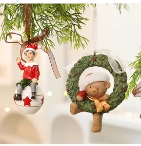 Detailed close-up of retro resin Christmas elf and teddy bear wreath ornaments.